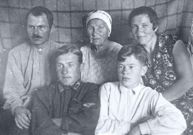 Борис уже восьмиклассник. Сидит рядом с родственником, военным лётчиком Виктором Юрецким. За ними - отец, бабушка и мама.