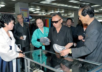 Ким Чен Ир осматривает обувные товары. Июль 2011 г.