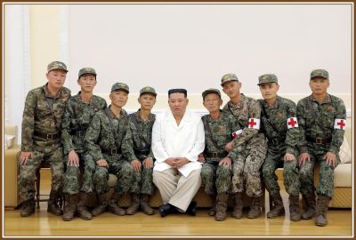Уважаемый Ким Чен Ын поздравляет бойцов с выдающимися подвигами, совершенными ими в борьбе против эпидемии в столице, и фотографируется с ними на память. 18 августа 111 года чучхе (2022).