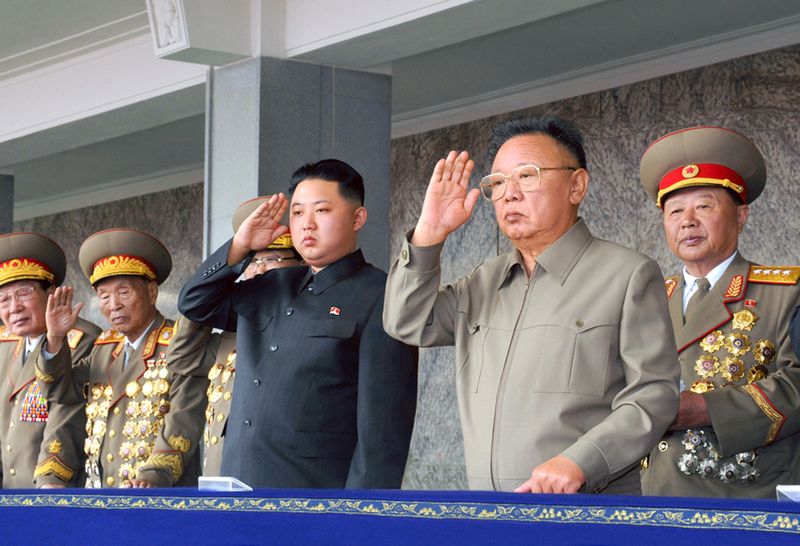 Ким Чен Ир и Ким Чен Ын отвечают на приветствие воинов на военном параде. Октябрь 99 г. чучхе (2010).