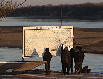 Китайские рыбаки рассматривают новую карту острова Большой Уссурийский. Российско-китайская граница, 2008 год  Reuters